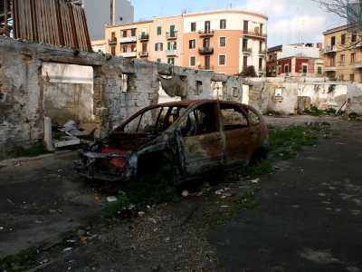 Siamo a pochi metri a sud del passaggio a livello della sud-est, di fronte a un autolavaggio. A ridosso dei binari della ferrovia si trova l�ex campo rom. Entriamo e ci ritroviamo in un cortile in totale disfacimento